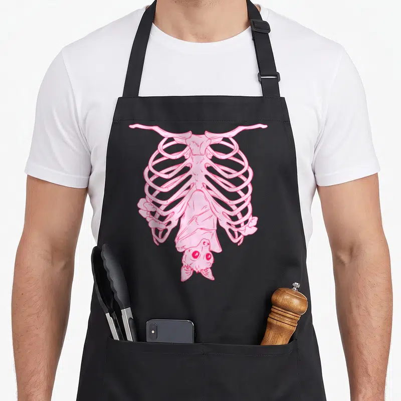 Witchy goth apron - Pink line-art bat hanging upside down inside ribcage sketch — shown on a black cotton canvas apron against a white background