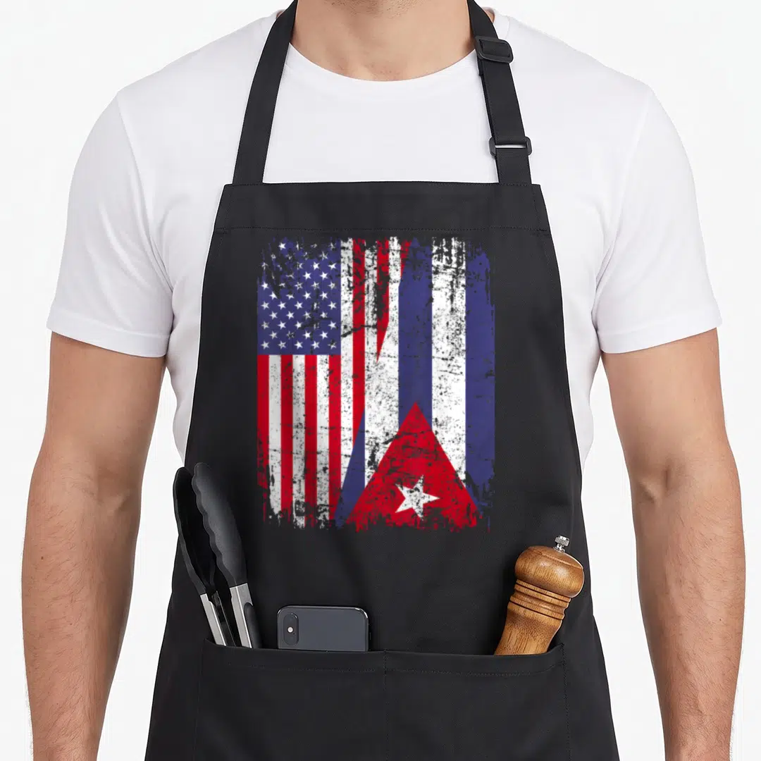 Cuban root american flag apron - Two flags merged side-by-side in red white and blue with distressed weathered texture — shown on a black cotton canvas apron against a white background