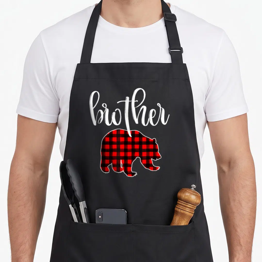 Brother bear buffalo plaid christmas apron - White brother script above a red and black buffalo plaid bear silhouette — shown on a black cotton canvas apron against a white background