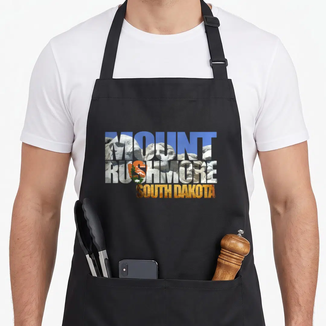 Mount south girl apron - MOUNT RUSHMORE SOUTH DAKOTA text filled with monument photo and NPS logo — shown on a black cotton canvas apron against a white background