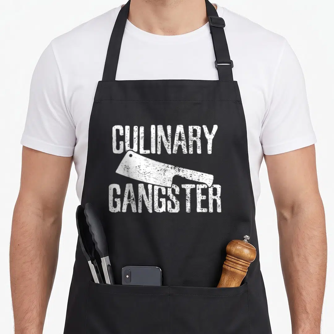 Koch culinary gangster apron - White distressed cleaver between CULINARY and GANGSTER text — shown on a black cotton canvas apron against a white background