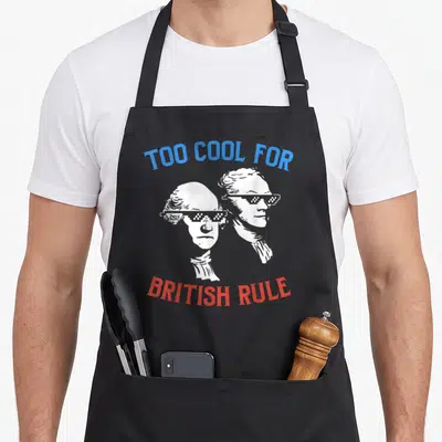 Rule 4th of july apron - Two founding fathers in pixelated sunglasses with arched text above and below — shown on a black cotton canvas apron against a white background
