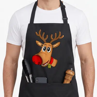 Nose reindeer apron - Cartoon brown reindeer head with red nose, red collar, and gold bell — shown on a black cotton canvas apron against a white background