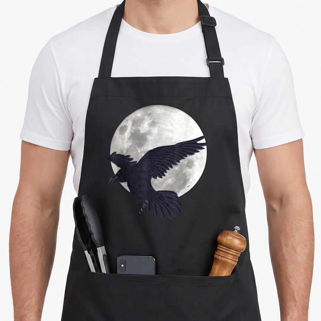 Night gothic apron - Realistic raven flying in front of a large full moon in dark purple and grey — shown on a black cotton canvas apron against a white background