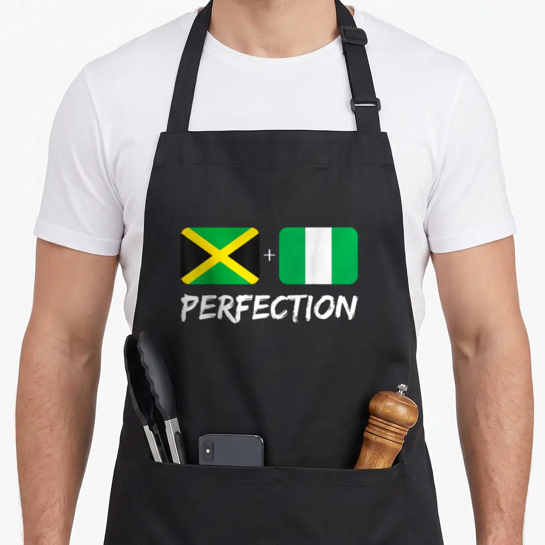 Nigerian heritage aprons - Two flags with plus sign and PERFECTION text in green yellow white black — shown on a black cotton canvas apron against a white background