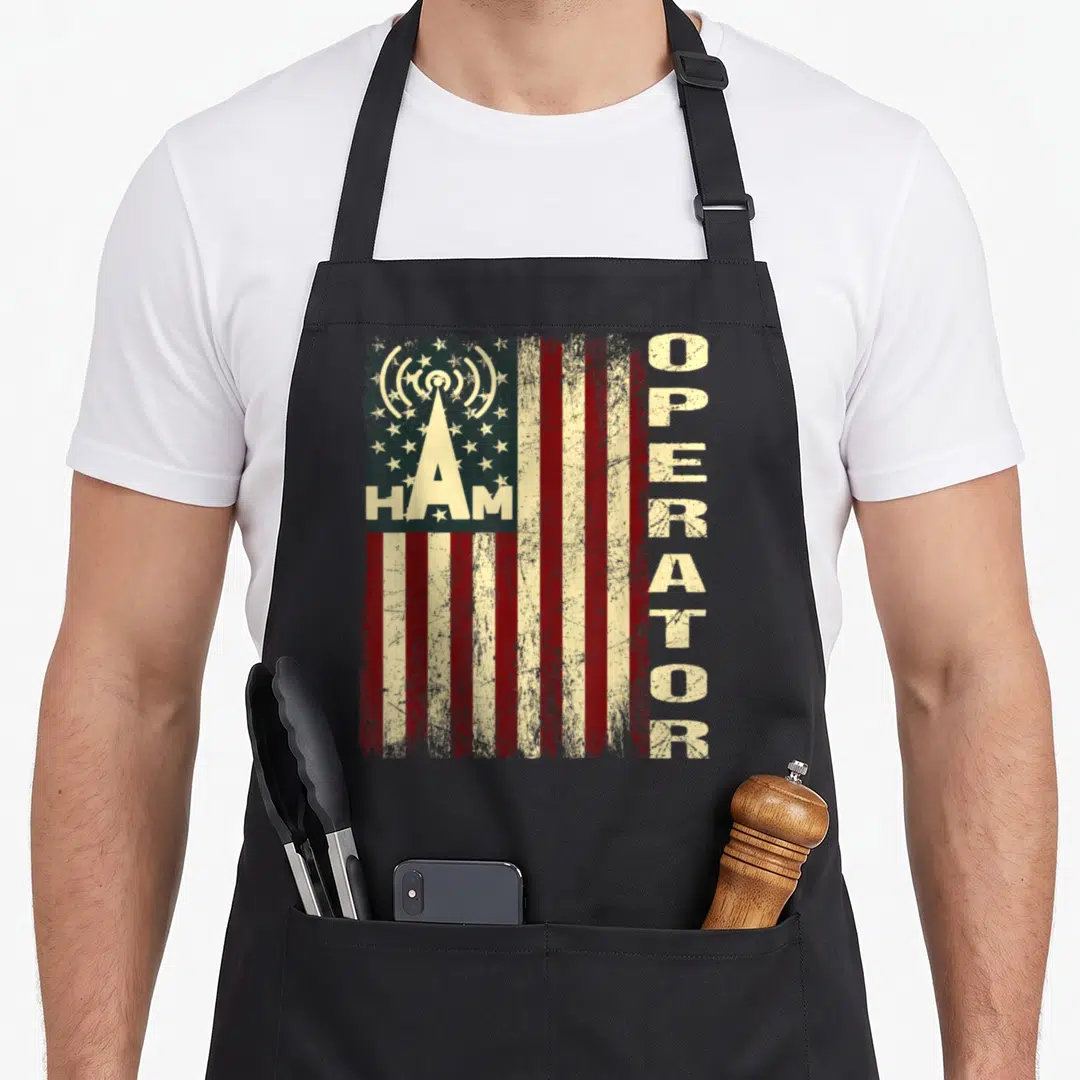 Flag patriotic apron - Distressed USA flag with radio tower and HAM OPERATOR text in red white blue beige — shown on a black cotton canvas apron against a white background