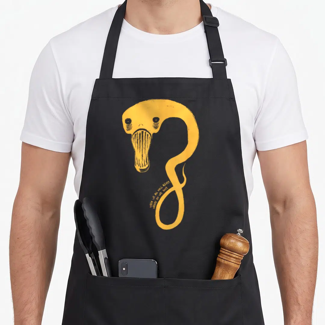 Billie world music apron - Long curved orange creature with album title text printed along the bottom curve — shown on a black cotton canvas apron against a white background