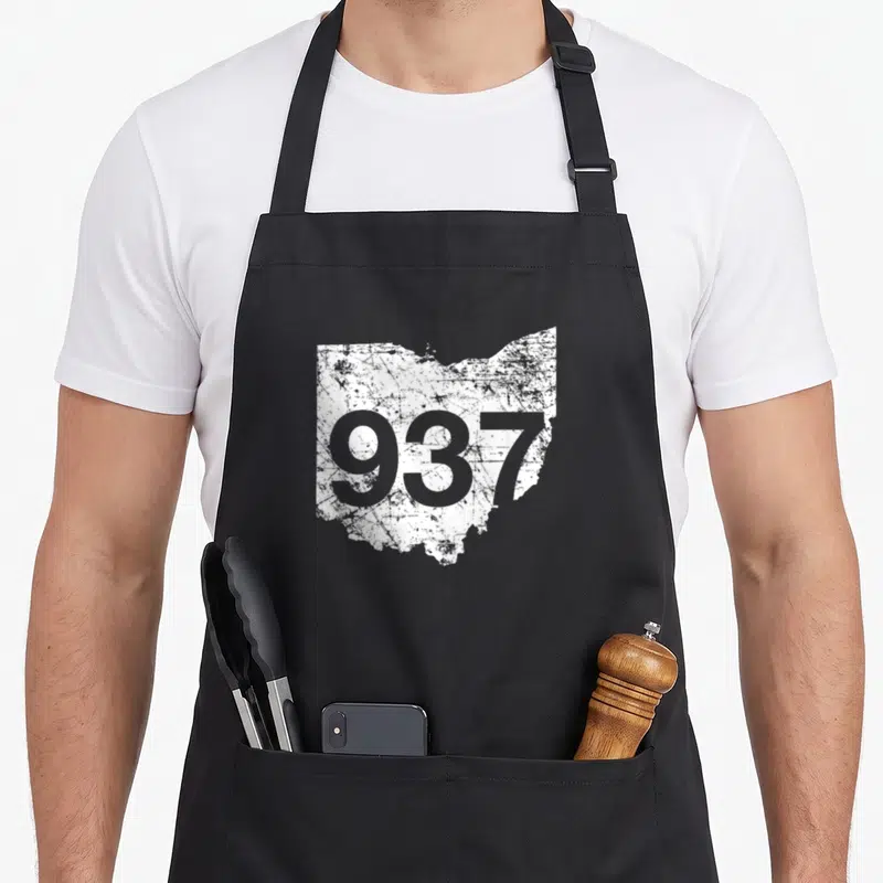 Dayton kettering apron - Number 937 printed over a distressed white silhouette of the state of Ohio — shown on a black cotton canvas apron against a white background