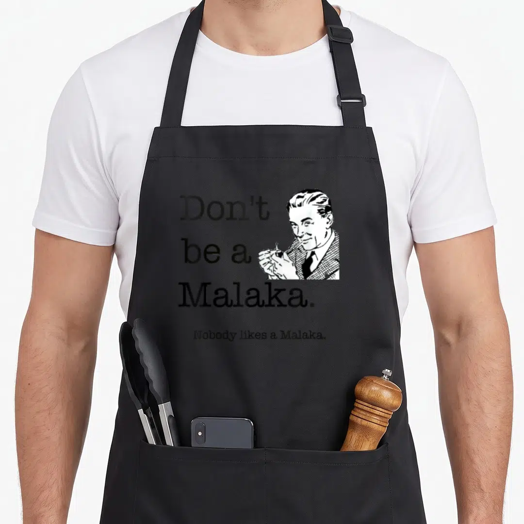 Malaka greek aprons - Retro man smoking pipe next to Don't be a Malaka text on grey background — shown on a black cotton canvas apron against a white background