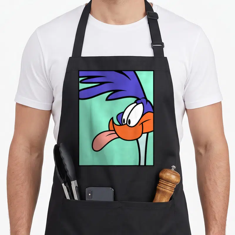 Vintage runner road apron - Cartoon bird head with blue feathers, orange beak, pink tongue on mint background — shown on a black cotton canvas apron against a white background