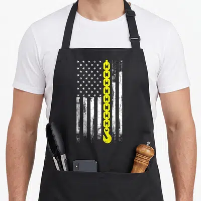 Driver thin truck apron - Distressed white flag with vertical yellow chain and hook running down center — shown on a black cotton canvas apron against a white background