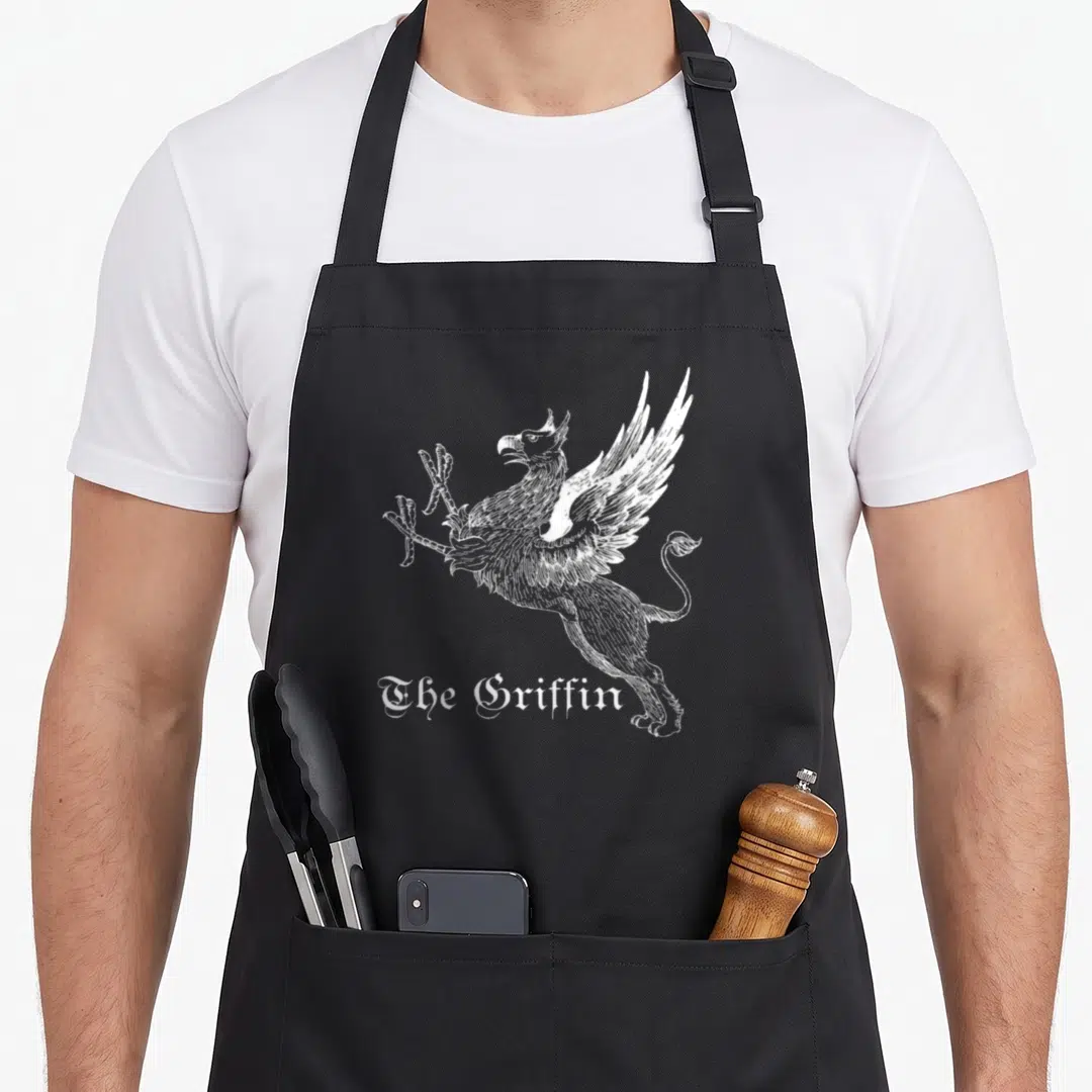 Griffin mythical apron - White line art griffin with gothic text The Griffin on black background — shown on a black cotton canvas apron against a white background