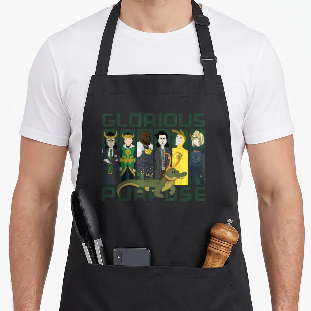 Variant purpose of apron - Loki variants in six panels with green alligator and text Glorious Purpose — shown on a black cotton canvas apron against a white background