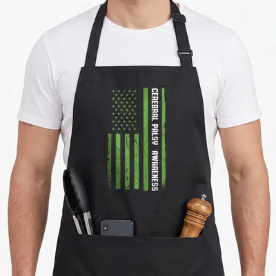 Cerebral american flag apron - Vertical green and white distressed USA flag with vertical text reading CEREBRAL PALSY — shown on a black cotton canvas apron against a white background