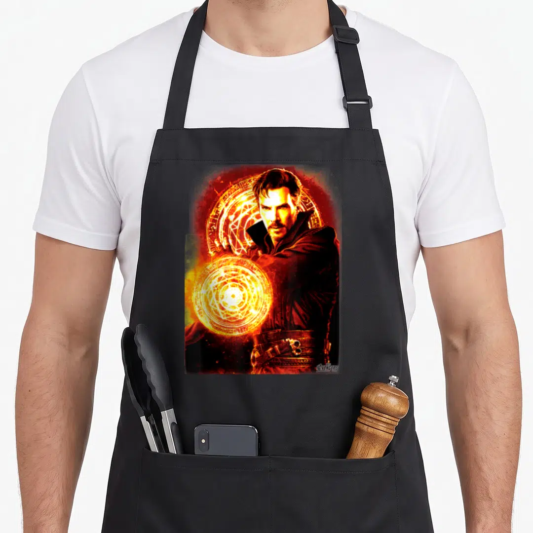 Infinity dr apron - Doctor Strange photo with two orange magic circles and Avengers logo on red and black background — shown on a black cotton canvas apron against a white background