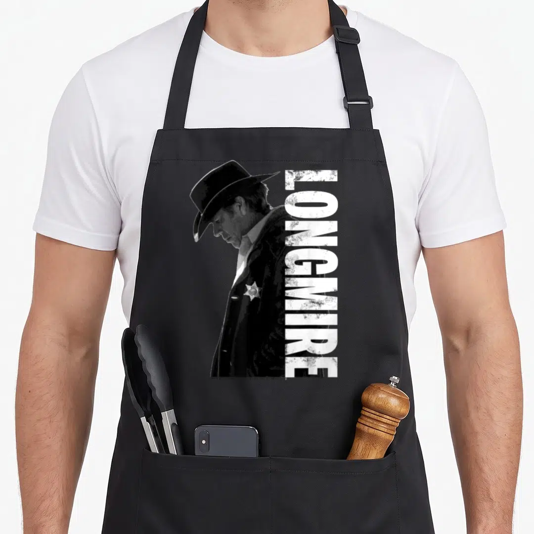 Longmire crew apron - Black and white profile of a man in a hat and badge next to vertical text — shown on a black cotton canvas apron against a white background