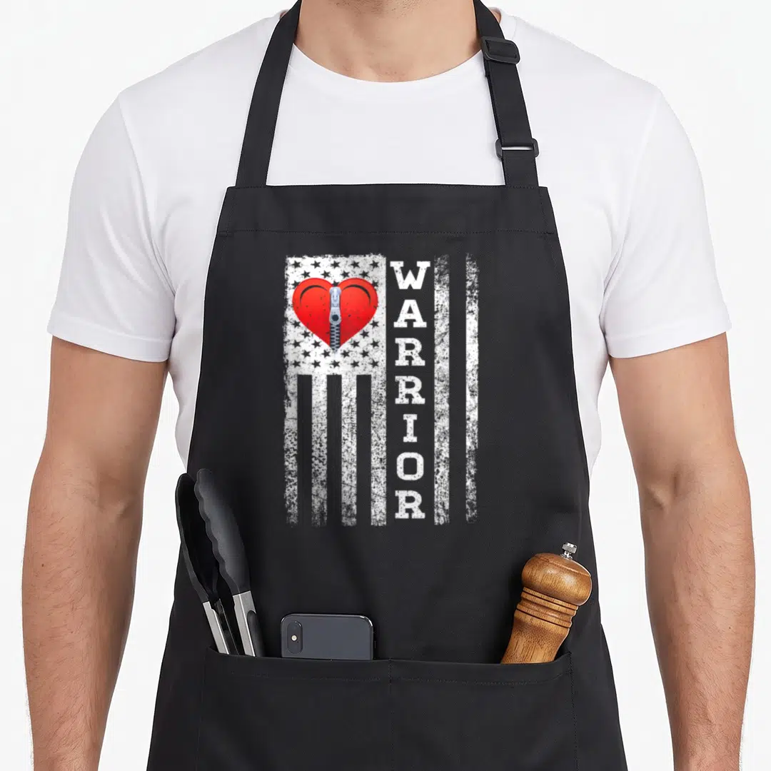 Warrior open apron - Distressed white flag with red zipper heart and vertical WARRIOR text — shown on a black cotton canvas apron against a white background