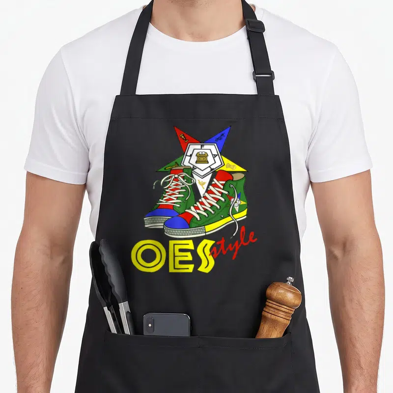 Oes ring apron - Two sneakers before five-pointed star with OES style text in yellow and red — shown on a black cotton canvas apron against a white background