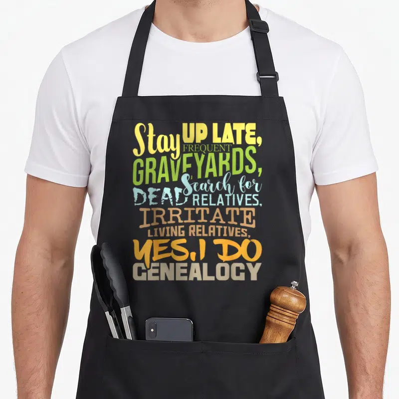 Genealogy genealogist family aprons - Stacked colorful text reading stay up late frequent graveyards search for dead — shown on a black cotton canvas apron against a white background