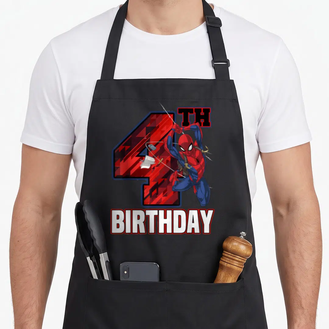 Web birthday apron - Spider-Man leaping before red patterned 4 TH BIRTHDAY text in cartoon style — shown on a black cotton canvas apron against a white background