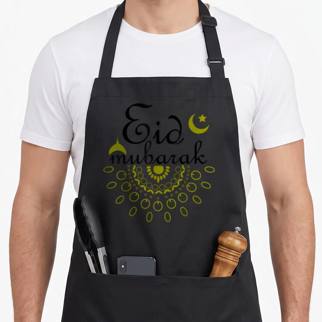 Ramadan eid apron - Black Eid mubarak text with yellow crescent, star, dome, and mandala pattern — shown on a black cotton canvas apron against a white background