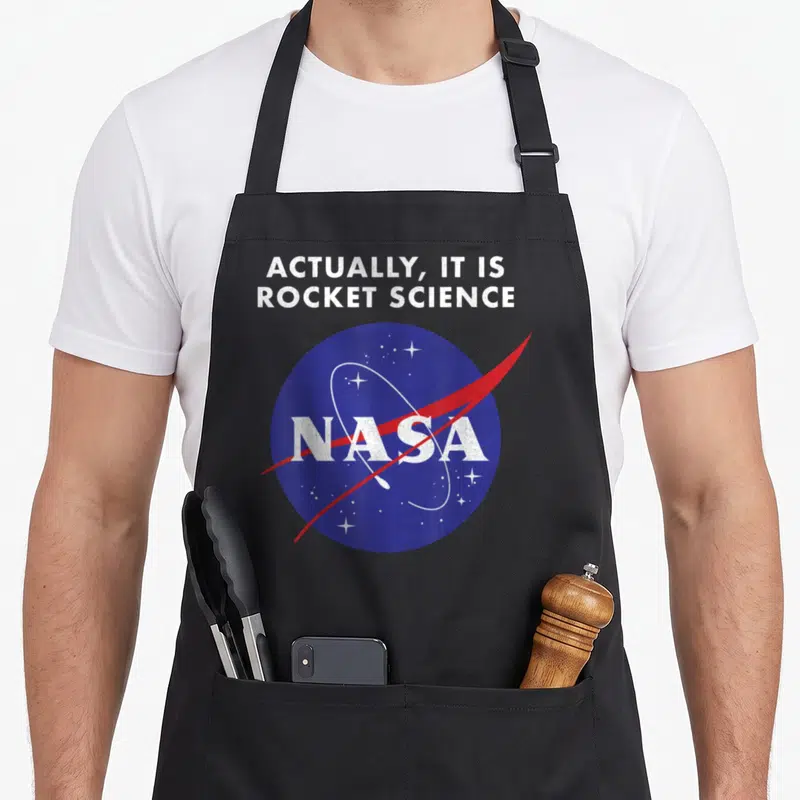Actually nasa apron - Distressed blue NASA logo with white stars and red swoosh under sarcastic text — shown on a black cotton canvas apron against a white background