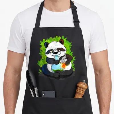 Bong smoking apron - Cartoon panda holding blue bong surrounded by green cannabis leaves on black fabric — shown on a black cotton canvas apron against a white background