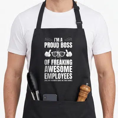 Freaking employee aprons - White stacked text reading I'm a proud boss of freaking awesome employees with boss — shown on a black cotton canvas apron against a white background