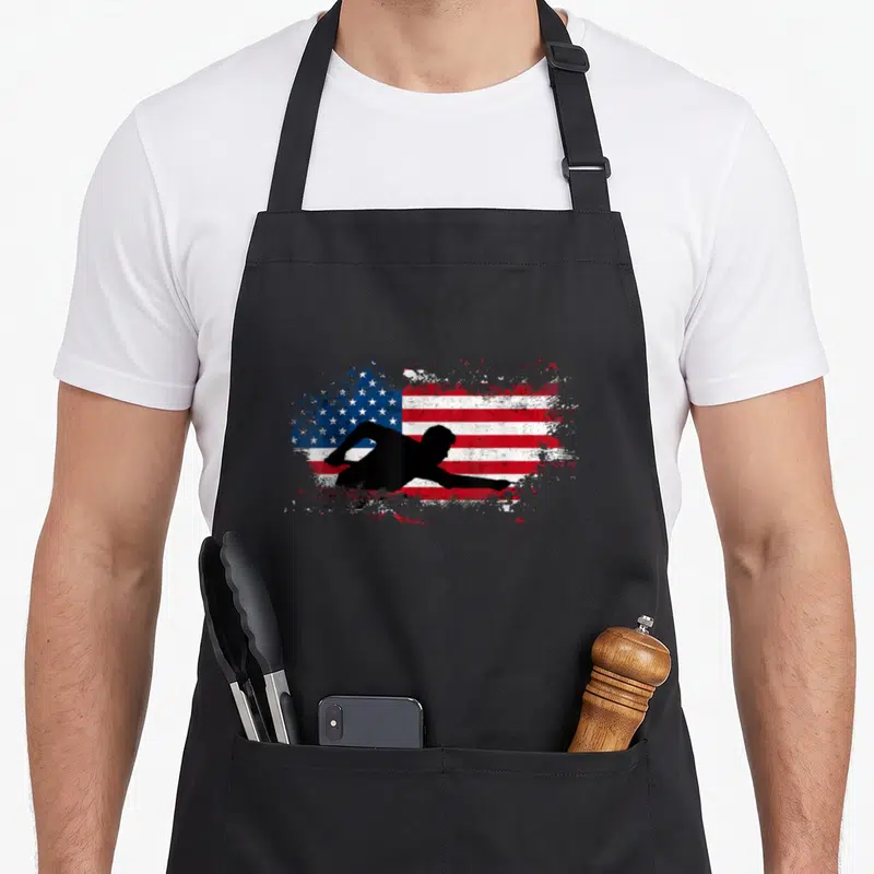 Sport billiards apron - Black diving athlete silhouette over distressed red white and blue USA flag — shown on a black cotton canvas apron against a white background