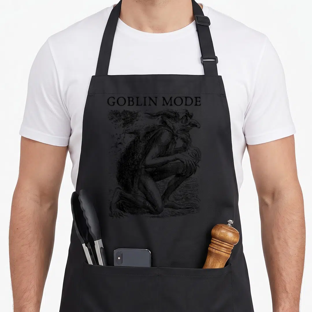 Mode goblin apron - Black line art of crouching goblin with GOBLIN MODE text above — shown on a black cotton canvas apron against a white background