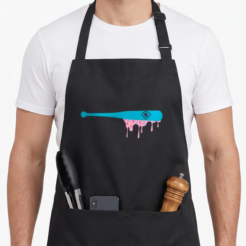 Baseball sprinkle apron - Blue baseball bat with pink icing drip and TR diamond logo — shown on a black cotton canvas apron against a white background
