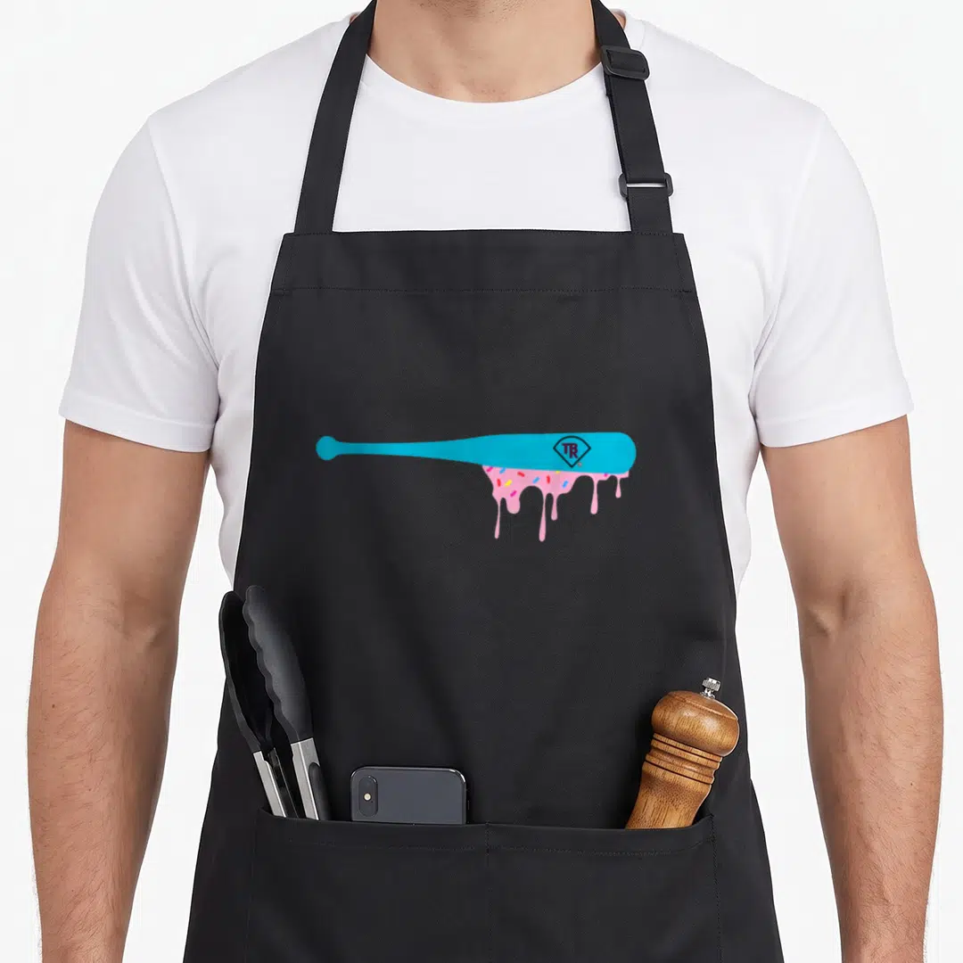 Baseball sprinkle apron - Blue baseball bat with pink icing drip and TR diamond logo — shown on a black cotton canvas apron against a white background