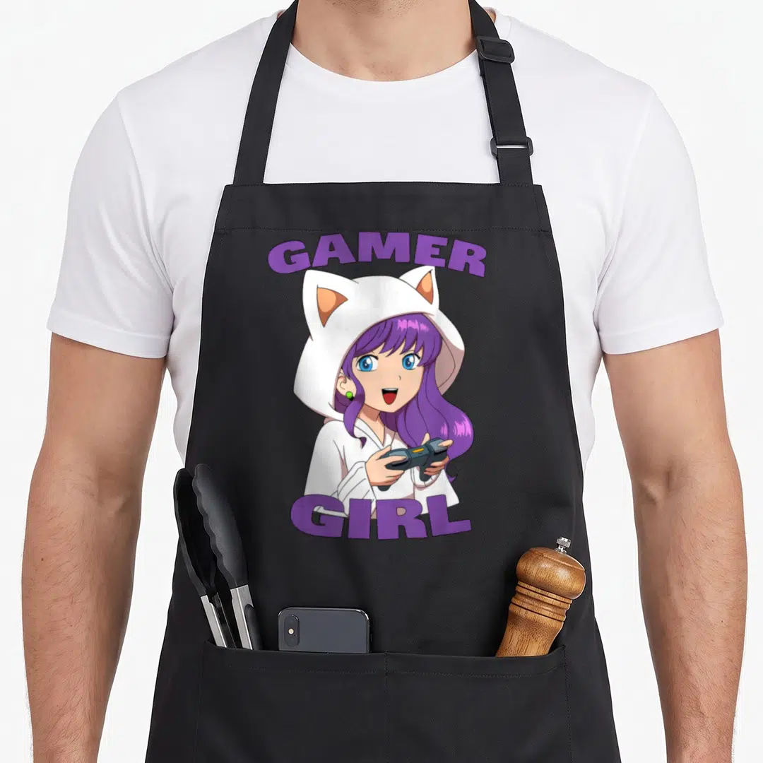 Funny gaming video game apron - Cartoon girl with purple hair wearing a white cat-ear hoodie and holding a video game — shown on a black cotton canvas apron against a white background