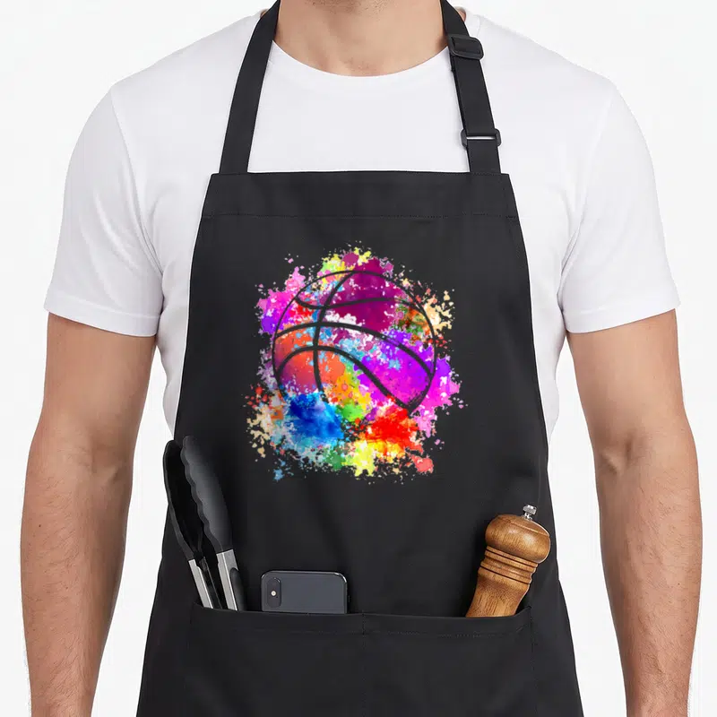 Baller basketball apron - White basketball outline over purple blue red yellow green watercolor paint splatter — shown on a black cotton canvas apron against a white background