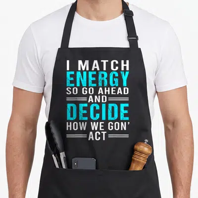 Match sarcastic apron - Stacked white and cyan text reading I Match Energy So Go Ahead And Decide How We Gon Act — shown on a black cotton canvas apron against a white background
