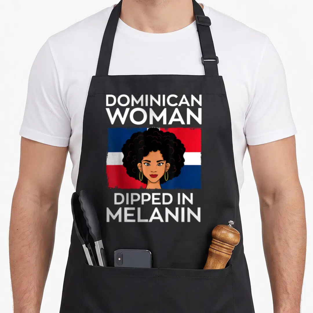 Dipped pride apron - Cartoon woman with afro before Dominican flag text reads Dominican Woman Dipped In Melanin — shown on a black cotton canvas apron against a white background