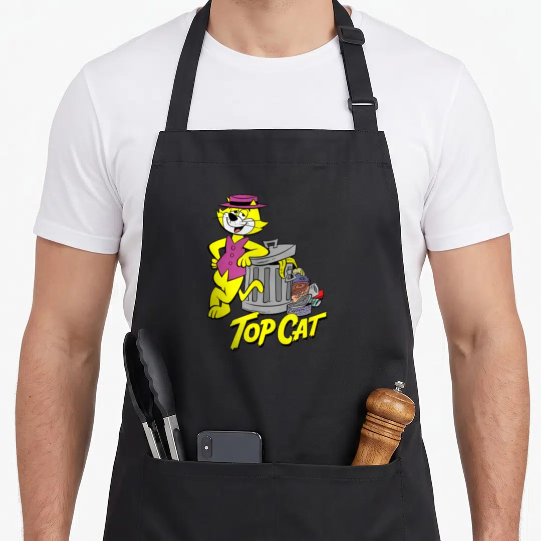 Garbage cat apron - Yellow cartoon cat in purple hat leaning on grey trash can with TOP CAT text — shown on a black cotton canvas apron against a white background