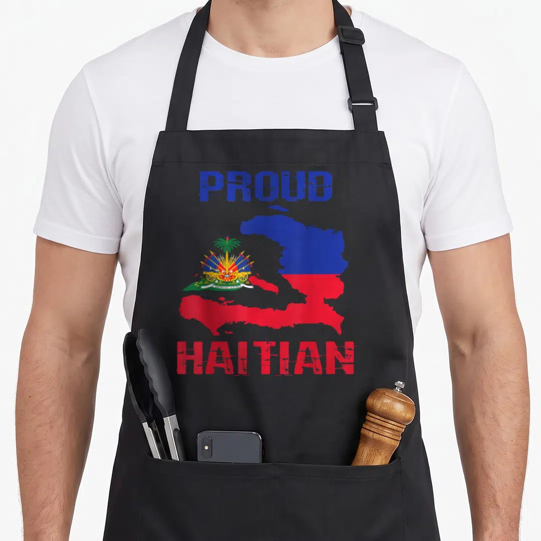 Haiti country apron - Distressed map of Haiti filled with flag colors and PROUD HAITIAN text — shown on a black cotton canvas apron against a white background
