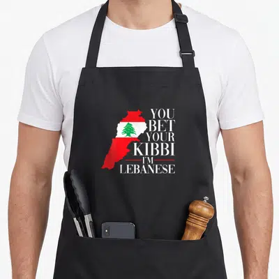 Bet lebanon apron - Lebanon map filled with red white green flag next to stacked white text — shown on a black cotton canvas apron against a white background