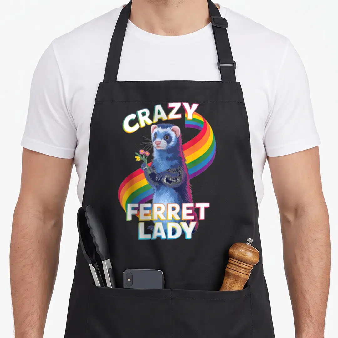 Vibrant rainbow apron - Blue ferret holding flowers with CRAZY FERRET LADY text on rainbow — shown on a black cotton canvas apron against a white background