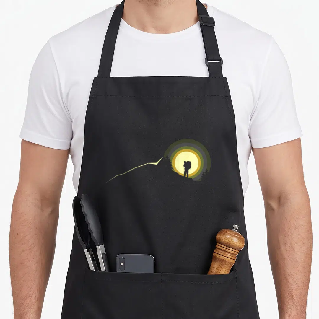 Hiking outdoor backpacking camping apron - Minimalist hiker silhouette in grey and olive circles with yellow sun — shown on a black cotton canvas apron against a white background