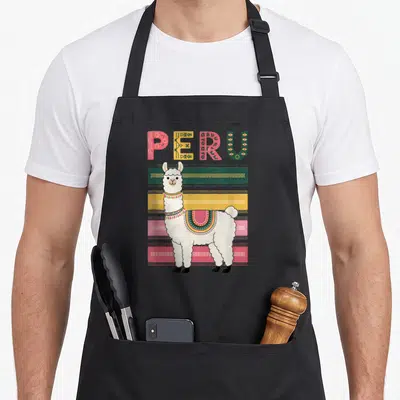 Llama peru peruvian apron - White cartoon llama standing before pink yellow green and red stripes under patterned PERU — shown on a black cotton canvas apron against a white background