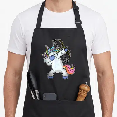 Dabbing bow apron - White unicorn standing holding compound bow with rainbow mane in cartoon style — shown on a black cotton canvas apron against a white background