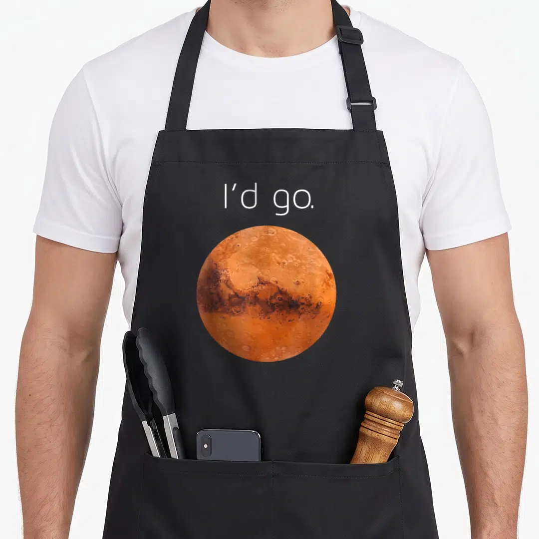 Colonize mars apron - I'd go text above orange brown photo of Mars planet — shown on a black cotton canvas apron against a white background