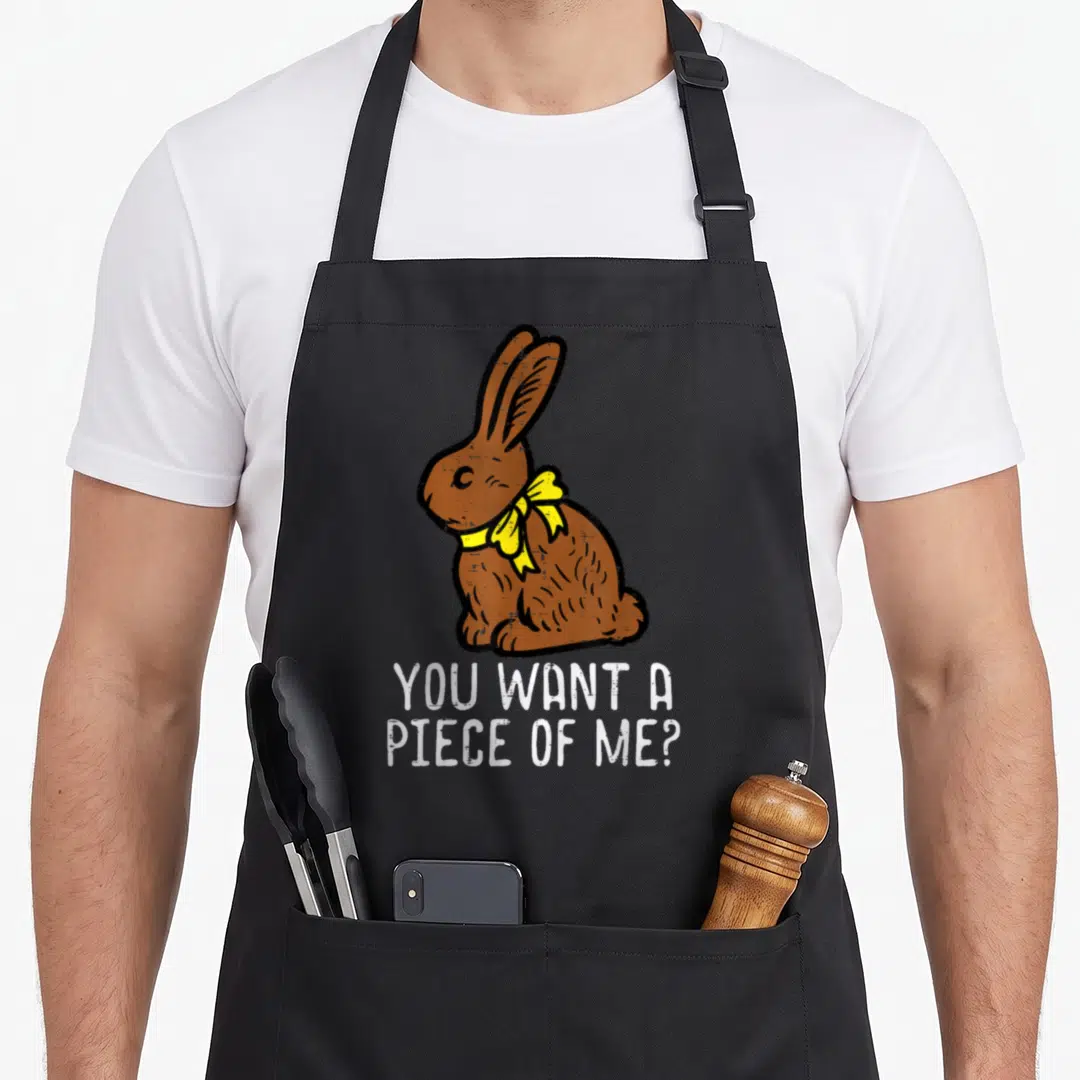 Chocolate rabbit easter bunny aprons - Brown cartoon rabbit with yellow bow and white text You Want A Piece Of Me — shown on a black cotton canvas apron against a white background