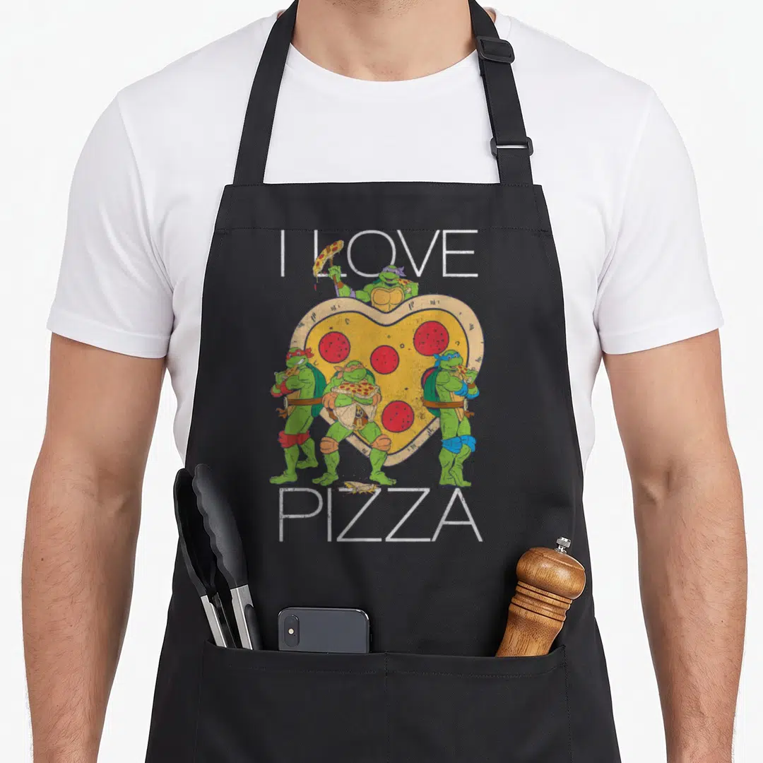 Vintage pizza apron - Four green turtles surrounding a heart-shaped pizza with I LOVE PIZZA text — shown on a black cotton canvas apron against a white background