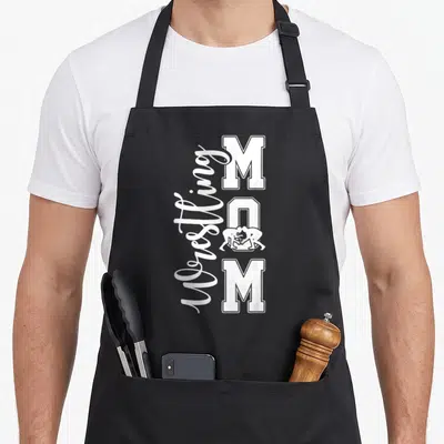 Wrestling mother's day aprons - White Wrestling MOM text with wrestlers inside the letter O on an apron — shown on a black cotton canvas apron against a white background