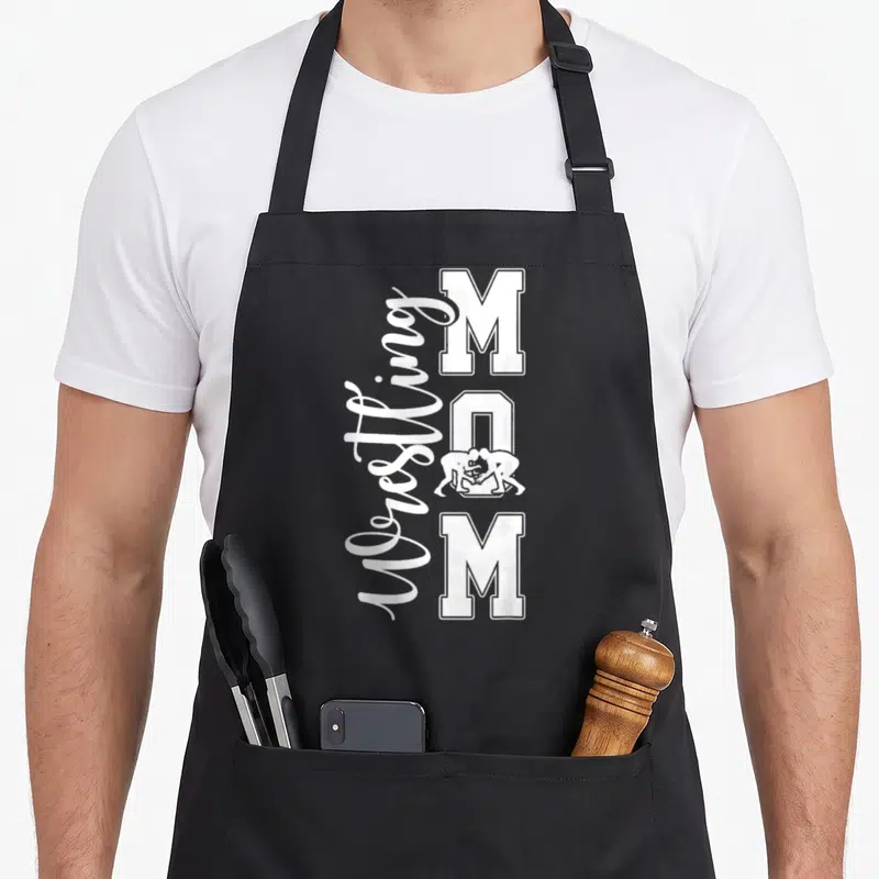 Wrestling mother's day aprons - White Wrestling MOM text with wrestlers inside the letter O on an apron — shown on a black cotton canvas apron against a white background