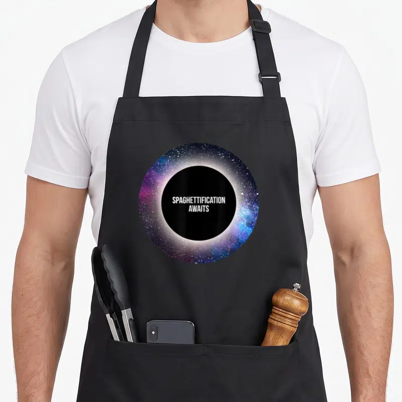 Spaghettification astrophysicist apron - Circular black hole with blue and purple disk and text SPAGHETTIFICATION — shown on a black cotton canvas apron against a white background