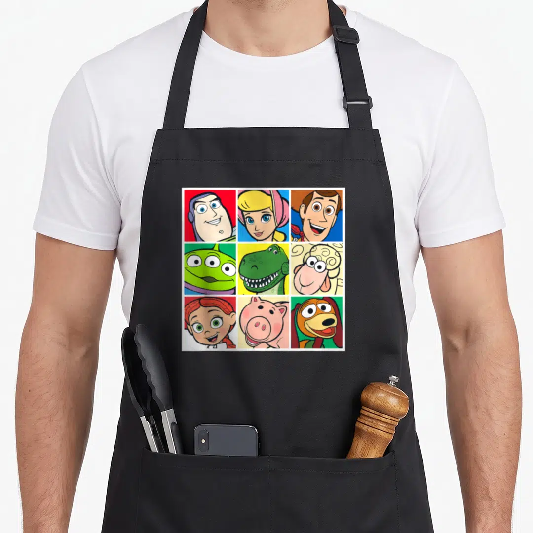 Cast camping apron - Nine cartoon character portraits in a 3x3 grid on red, blue, green, yellow, and pink backgrounds — shown on a black cotton canvas apron against a white background